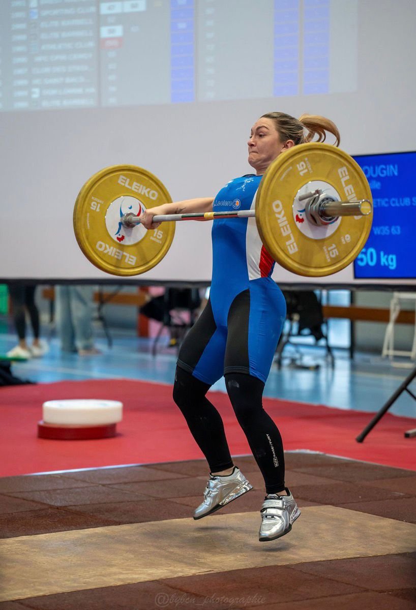 Camille Mougin en compétition d'haltérophilie, tirage de la barre en pleine extension